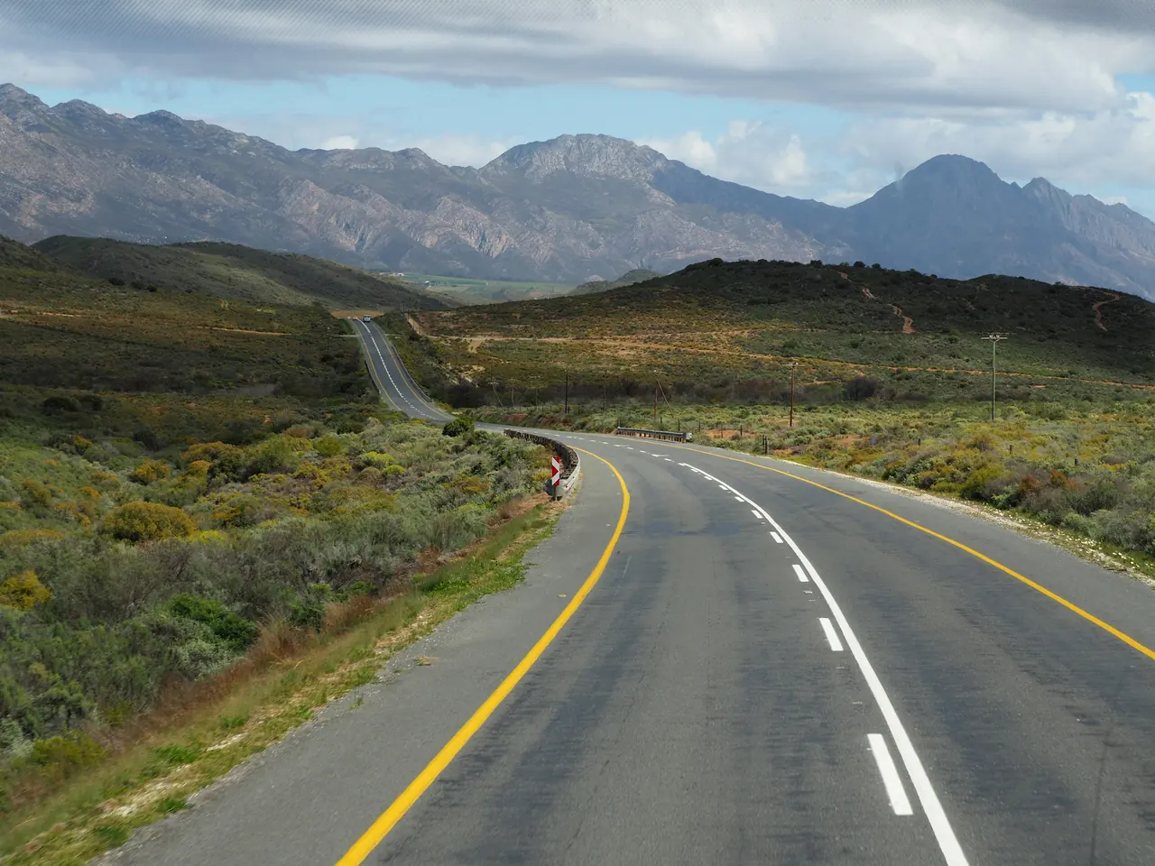 An open road winding towards the mountains